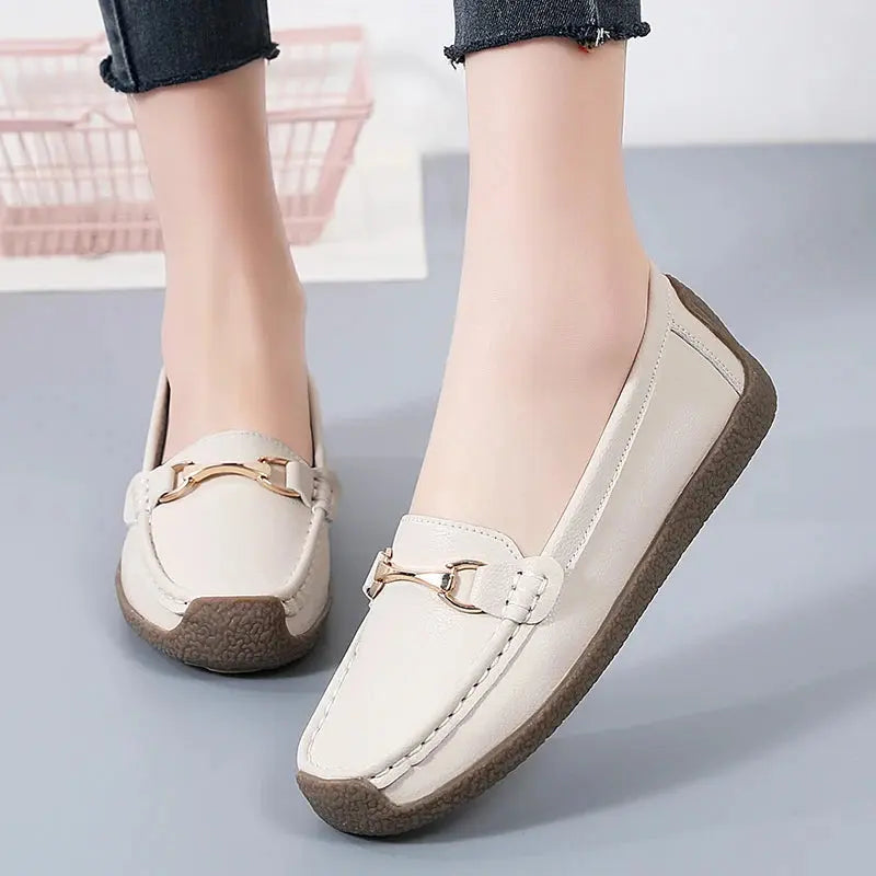 Women's slip-on moccasin flats in neutral tones, rounded toe, clean stitching, faux leather upper