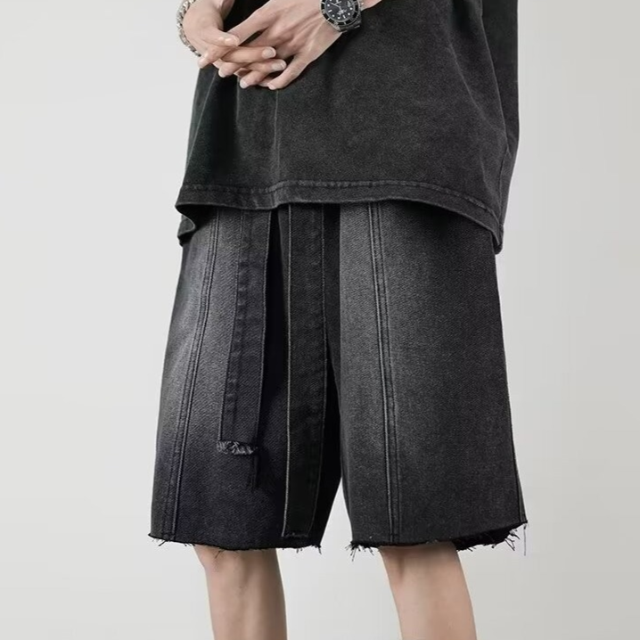 Washed blue denim relaxed-fit mid-thigh shorts with distressed fringe hem and elongated front ties