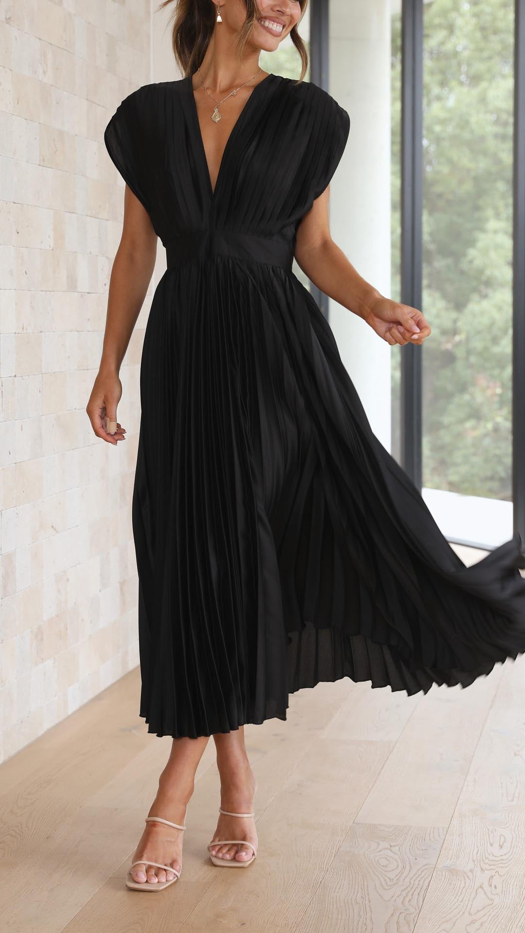 Elegant pleated maxi dress in flowing silhouette, featuring subtle luxury drape for sophisticated occasions