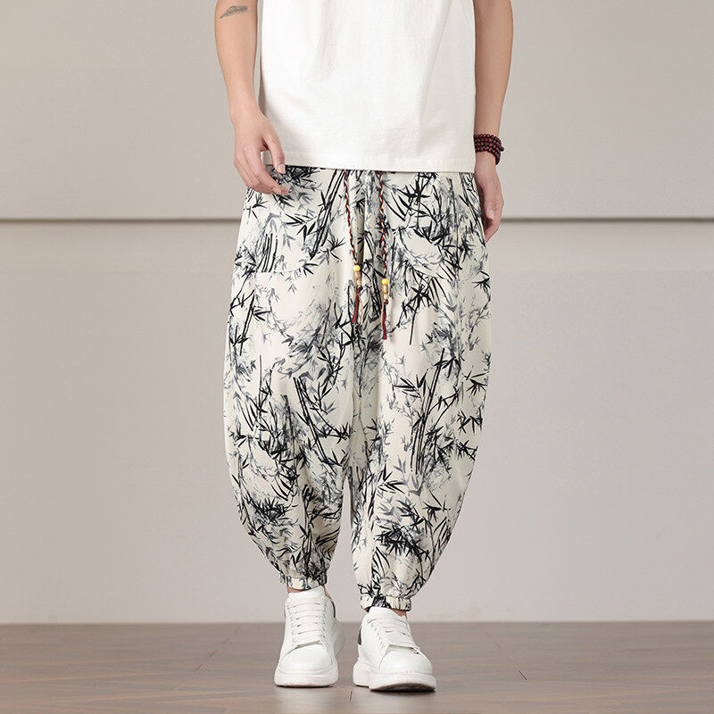 Black tapered joggers with allover bamboo print, elastic cuffs, and decorative bead drawstring