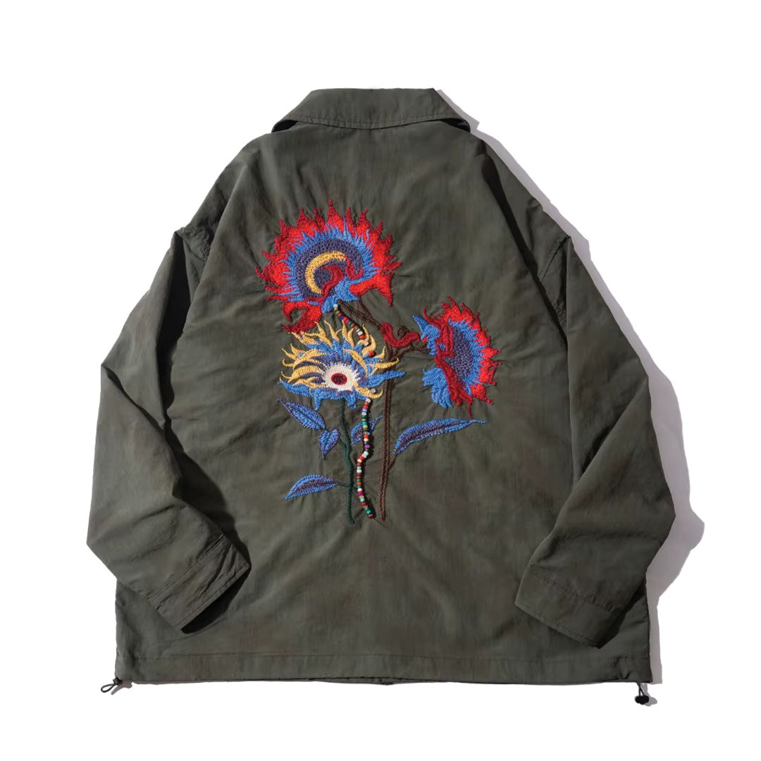 Beige floral embroidered shirt jacket with drawstring hem, long sleeves, and vintage-inspired button closure