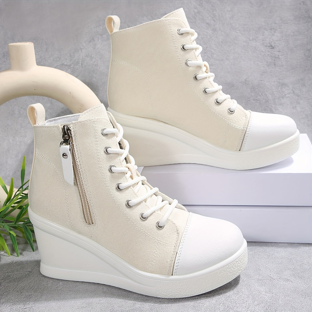 Rowan white canvas wedge sneaker with hidden heel lift, rubber toe cap, and side zipper