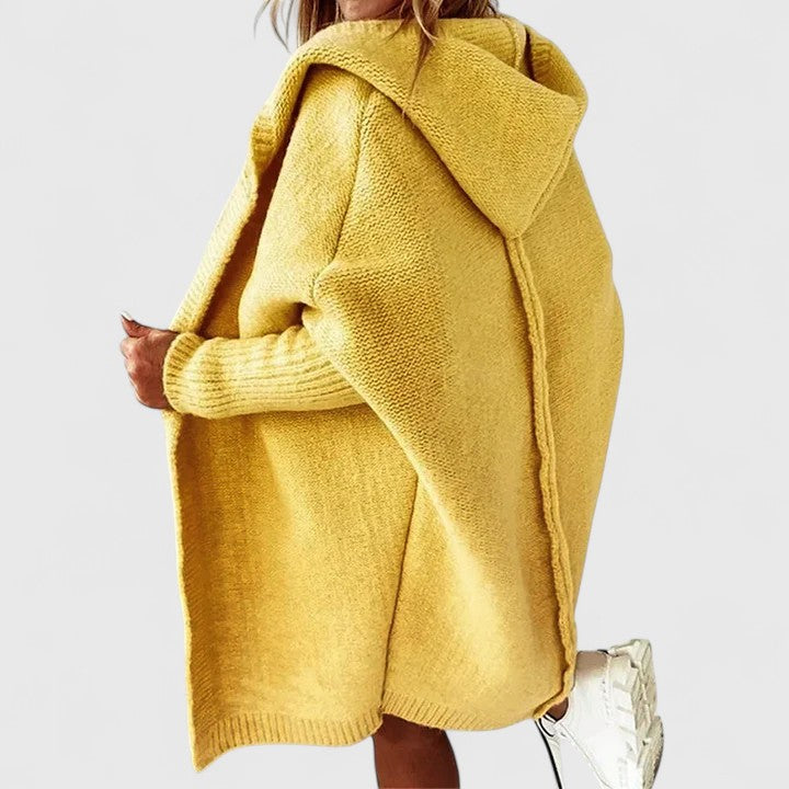 Oversized hooded knit cardigan in neutral tone, relaxed knee-length silhouette with cozy layering style