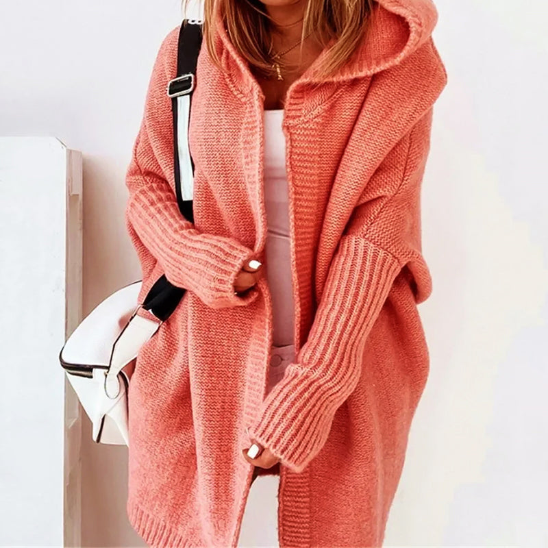 Oversized loose knit cardigan in neutral tone with generous hood and knee-length relaxed silhouette