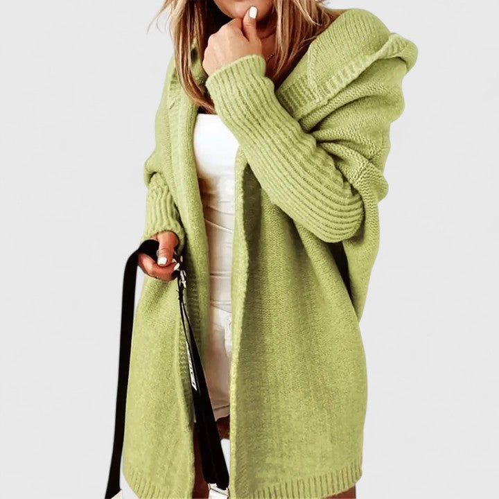 Oversized hooded knit cardigan in neutral tone, relaxed knee-length silhouette with cozy layering style