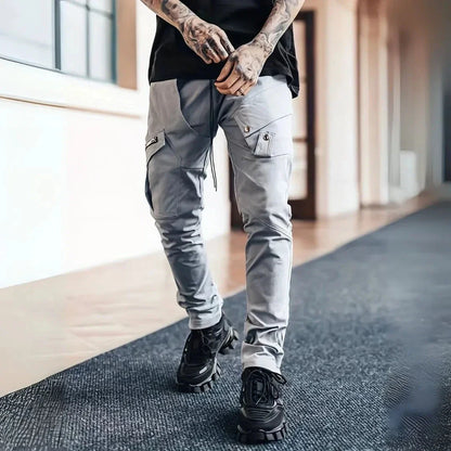 Men's slim tapered cargo pants in neutral tone with zip closure and multi-pocket utility design