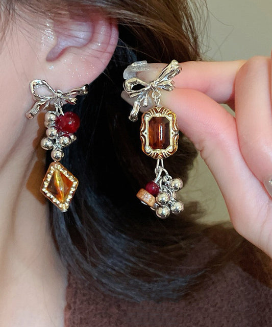 Boucles d'oreilles pendantes vintage asymétriques en alliage acrylique avec nœud ambré et pompon - Wavlynn