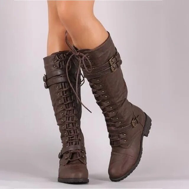 Women's black leather knee-high boots with lace-up front, buckle detail, and rugged sole for structured fit