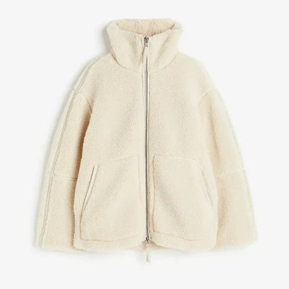 Women's sherpa fleece jacket in soft neutral tone, relaxed fit with high collar and front zipper