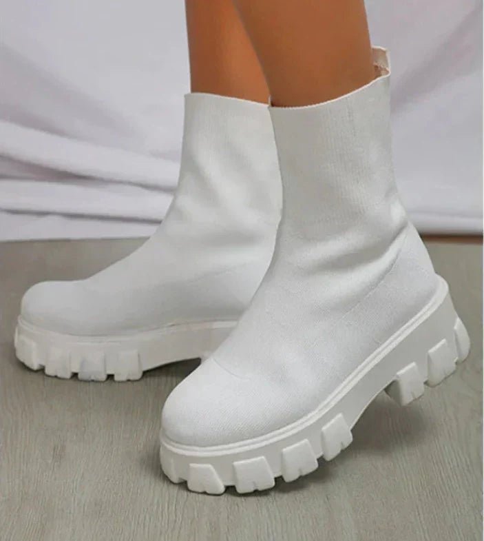 Women's black chunky heel slip-on boots with stretch-fit upper and rugged lug sole for bold streetwear style