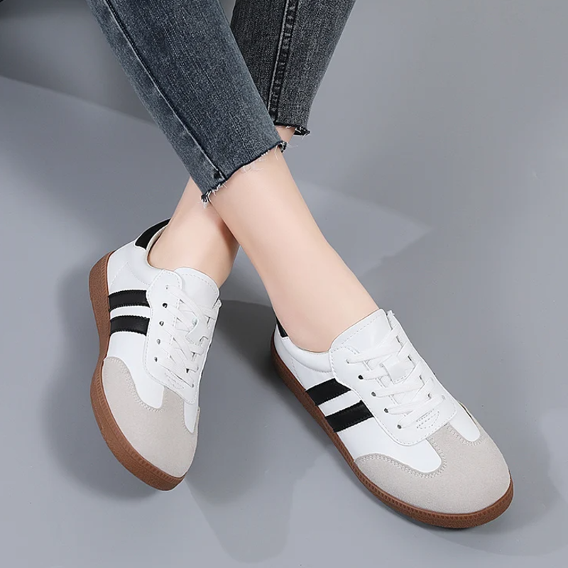 Women's white low-top sneakers with sleek minimalist silhouette and cushioned sole for everyday style