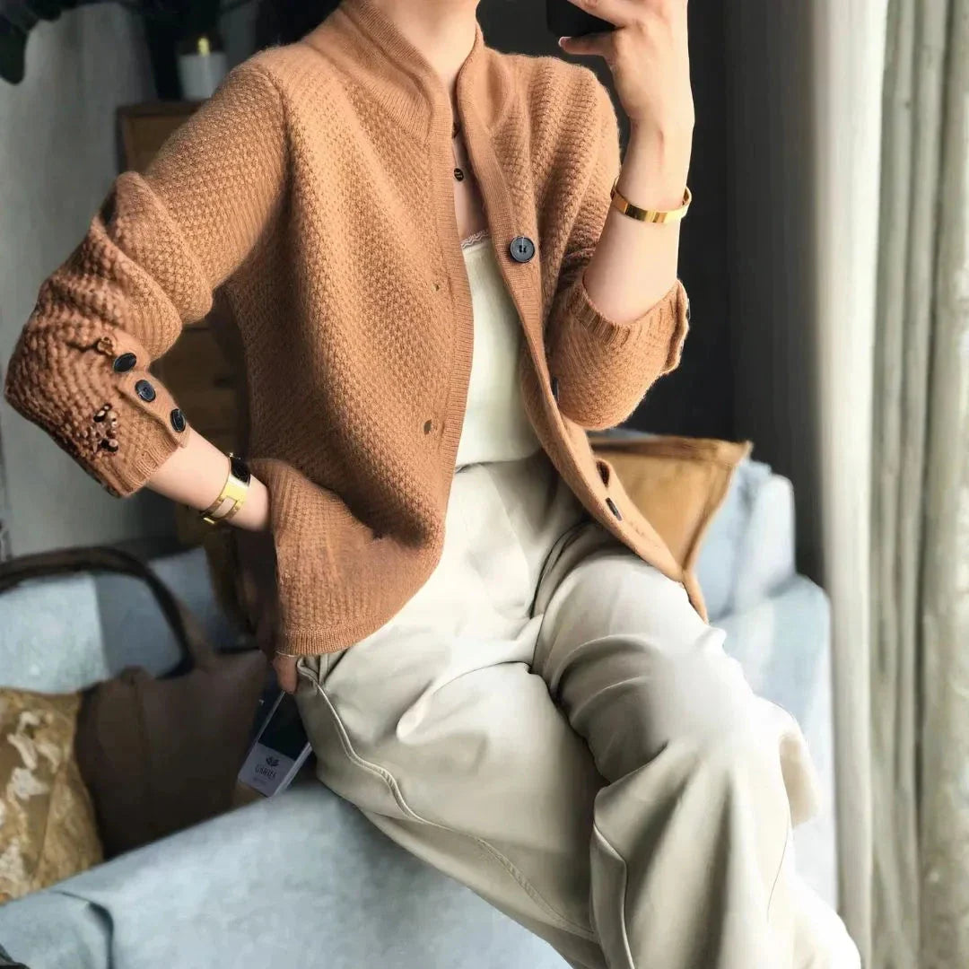 Women's ivory cashmere button cardigan with textured knit pattern, front closure, and functional pockets