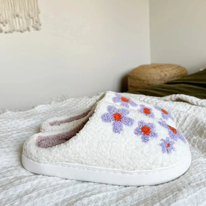 Women's purple fuzzy slip-on slippers with lavender and coral daisy embroidery and plush interior lining