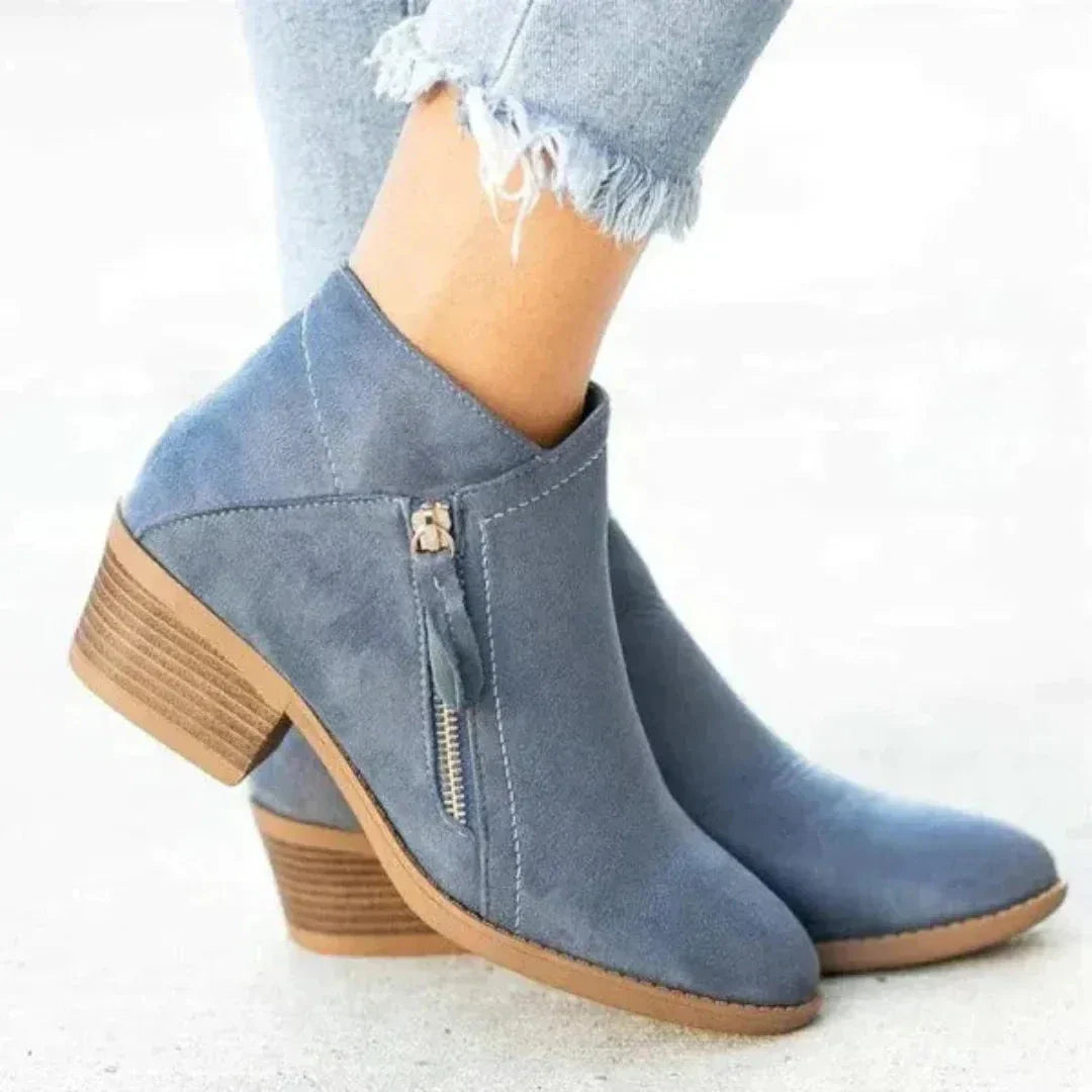 Women's tan suede ankle boots with low block heel, side zip closure, and sleek streamlined silhouette