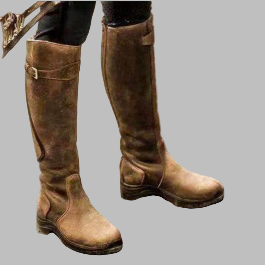 Women's knee-length distressed leather hiking boots in brown with buckled strap details and tall silhouette