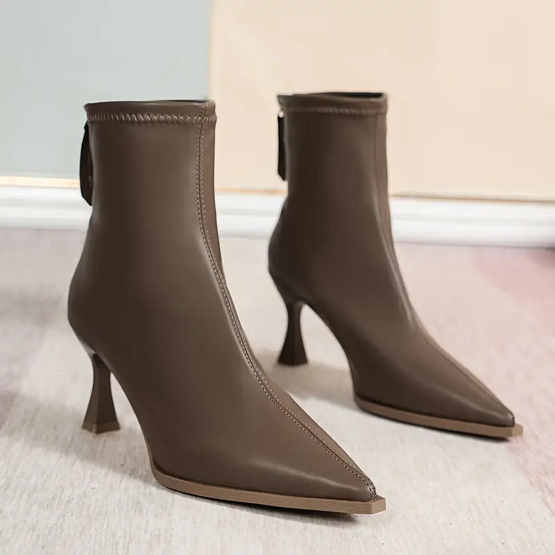 Black pointed-toe kitten heel boots with slender stiletto heel, luxe finish, and elegant silhouette