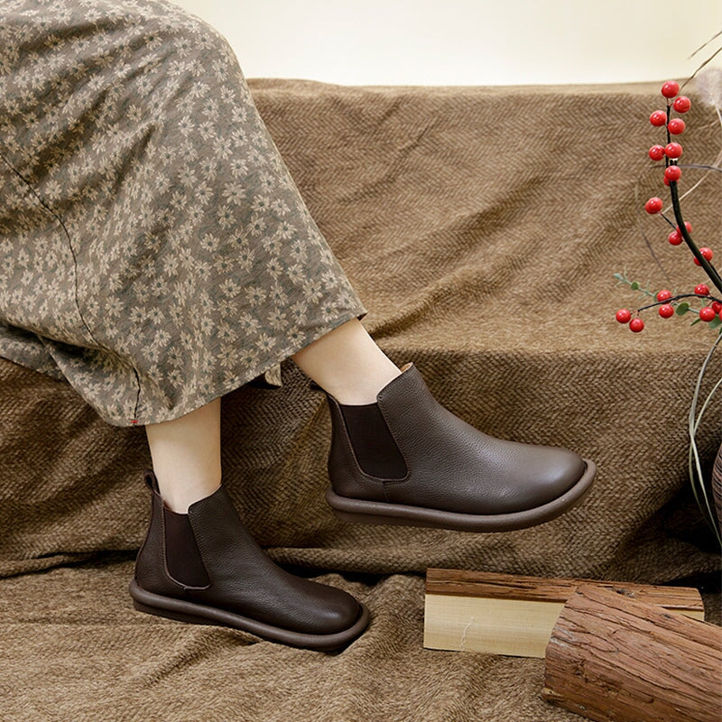 Black slip-on boots with sleek minimalist silhouette and smooth leg-lengthening design