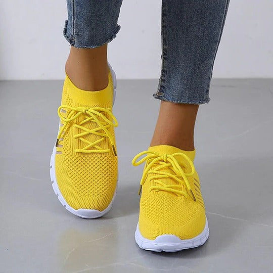 White lightweight athletic sneakers with breathable upper and cushioned insole for everyday wear