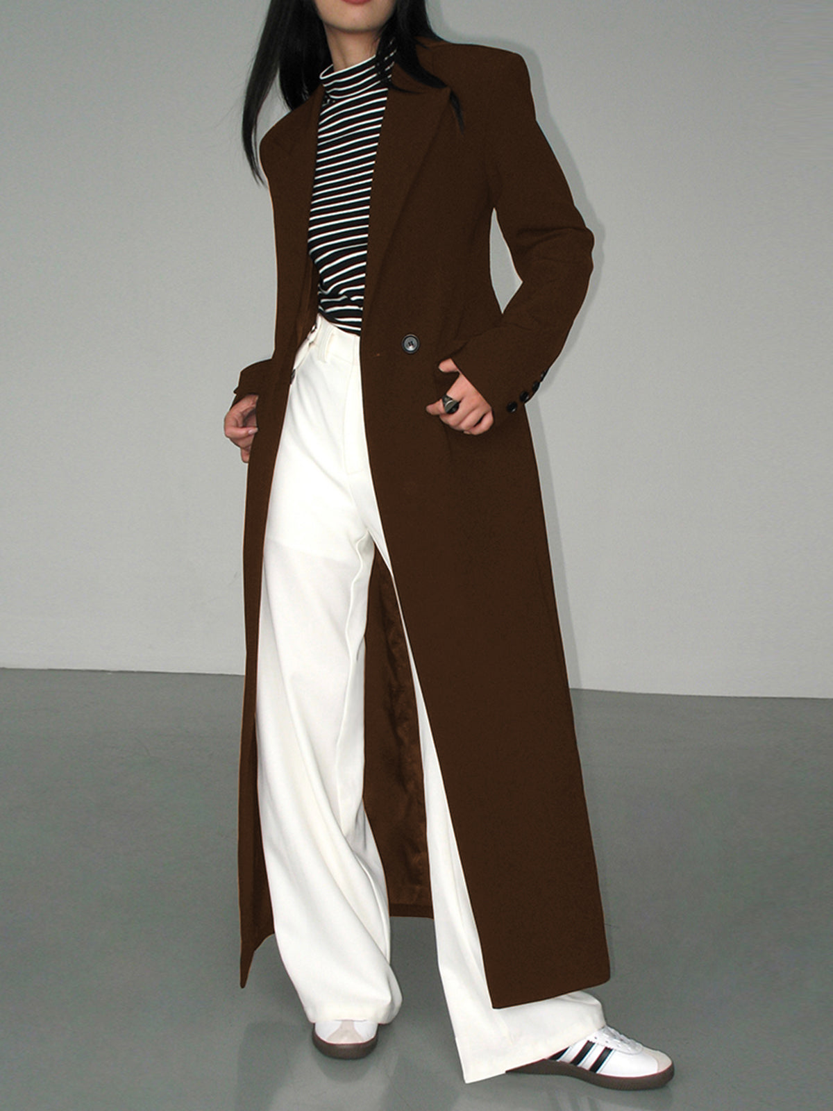 Women's longline blazer coat with collar, tailored silhouette, and functional pockets in structured fabric