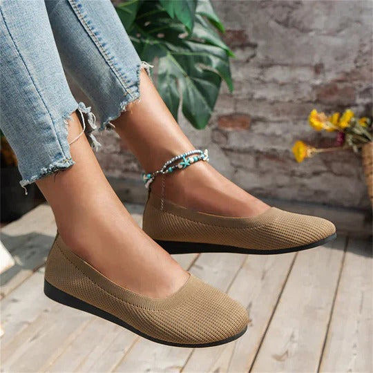 Beige cushioned indoor slippers with contoured footbed, adjustable fit, and textured grip sole