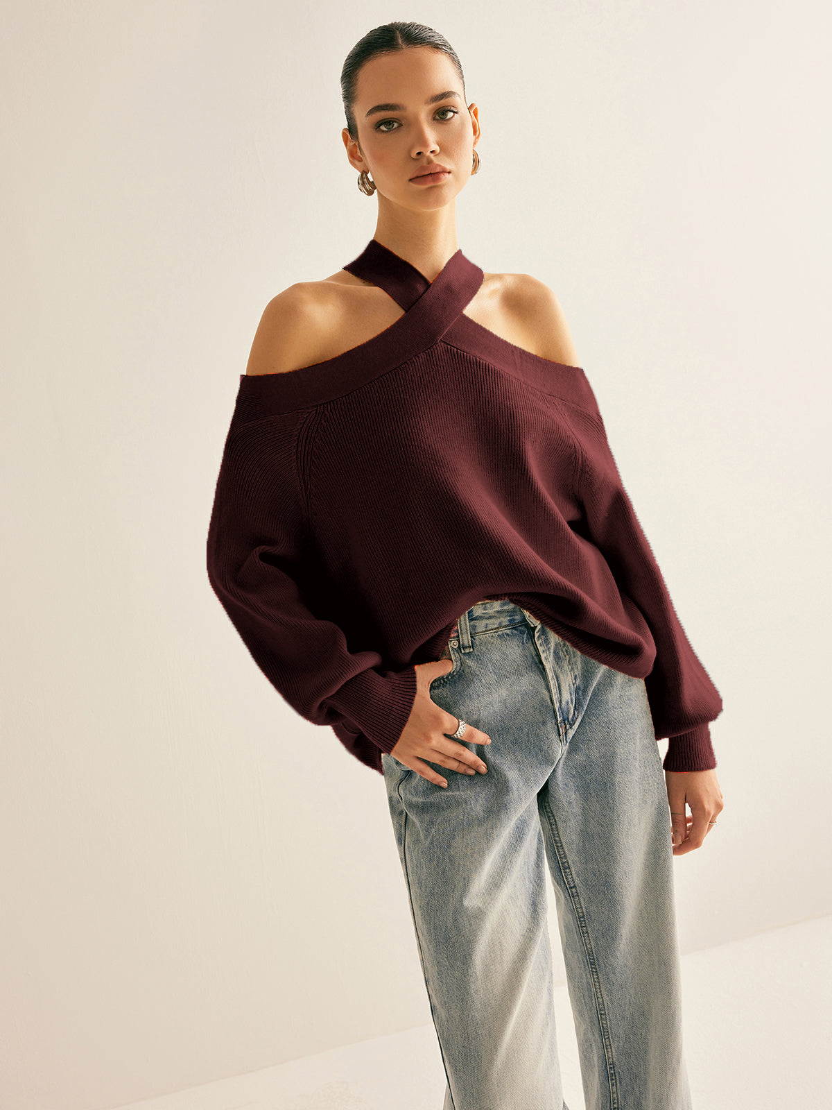 Ivory knit cold-shoulder sweater with crossover collar and elegant halter-style cut