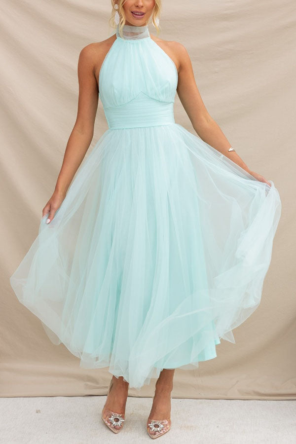 Women's blush tulle wedding guest dress with flowing layered skirt and flattering waist-cinching silhouette