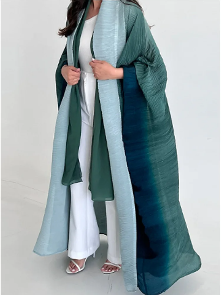 Women's oversized trench coat in neutral tone, full-length with pleated shawl collar and dramatic bat sleeves