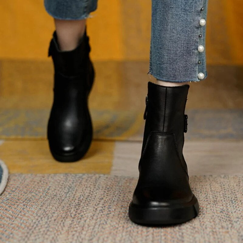 Women's black leather ankle boots with contemporary buckle detail, polished and versatile for everyday wear