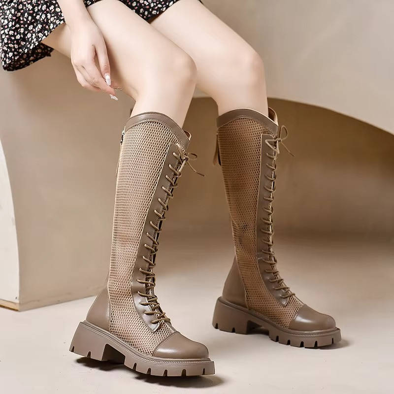 Black lace-up knee high boots with adjustable closure and elongated shaft for a polished silhouette