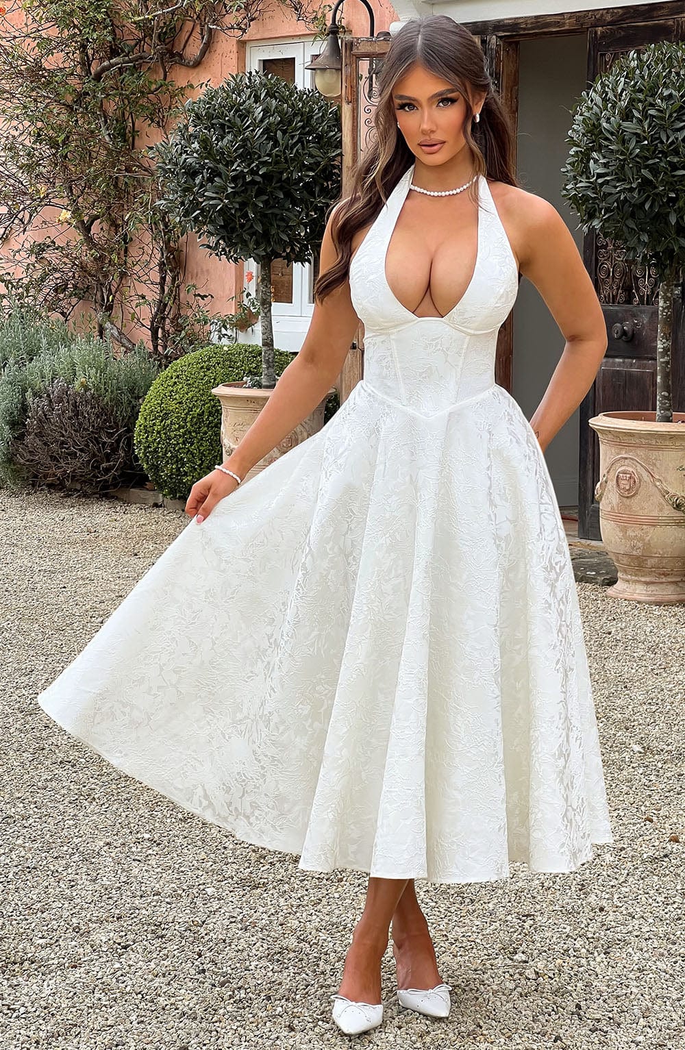 Ivory sleeveless V-neck wedding guest dress with intricate floral embroidery and feminine silhouette