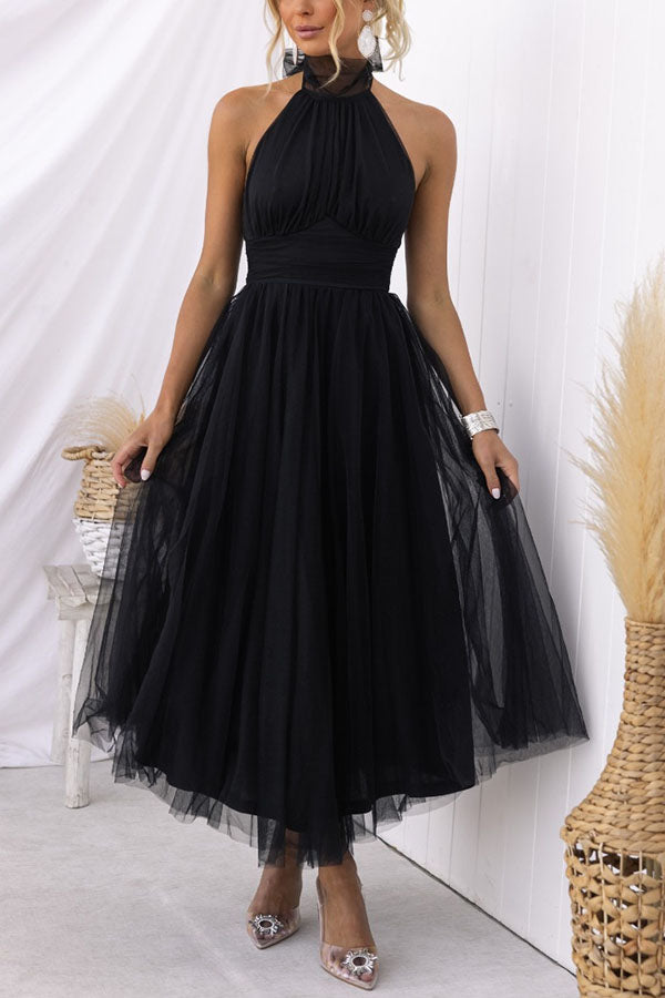 Women's blush tulle wedding guest dress with flowing layered skirt and waist-defining silhouette