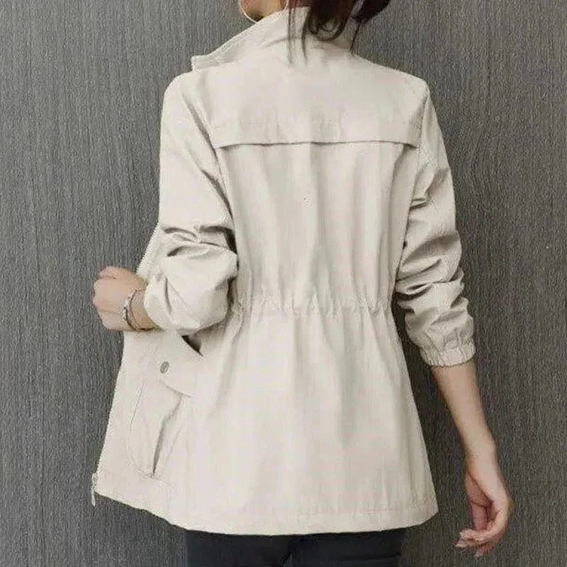 Lightweight beige trench coat streamlined cut adjustable waist raised collar storage pockets