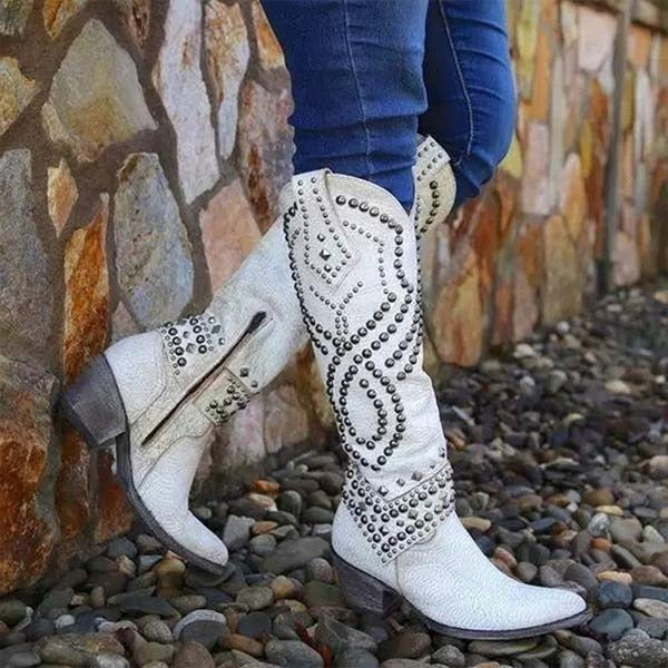 Women's brown knee-high western boots with pointed toe and studded accents for a bold statement look