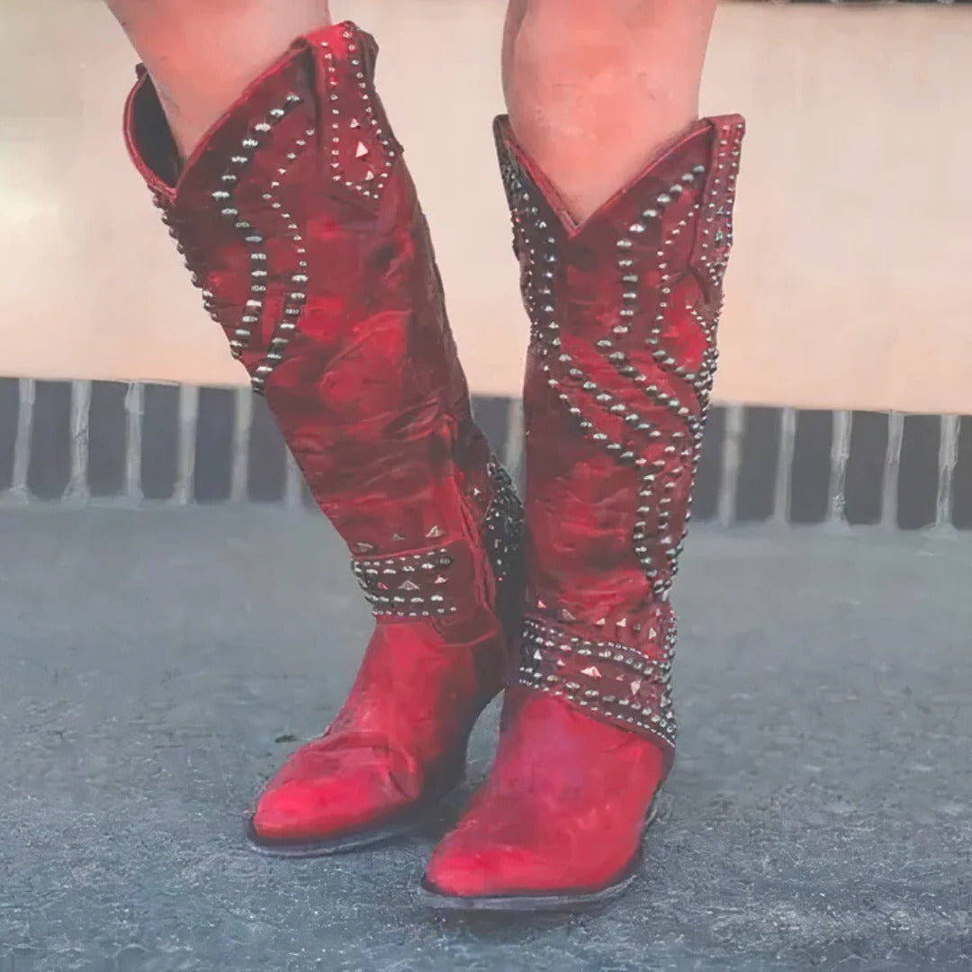 Women's brown knee-high western boots with pointed toe and studded accents for a bold modern look