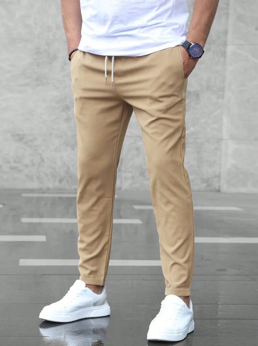 Men's casual stretch pants in neutral tone, slim tapered cut with elastic waistband for work and weekend