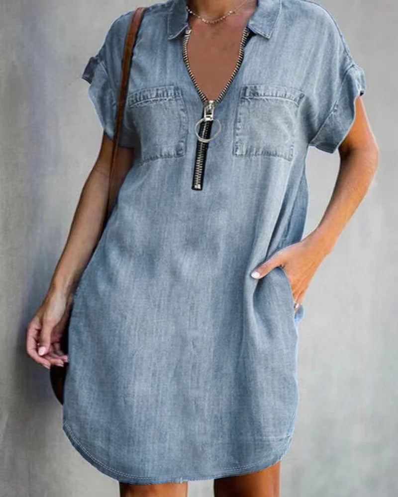 Women's relaxed-fit blue denim dress with short sleeves, front zipper closure, and utility pockets