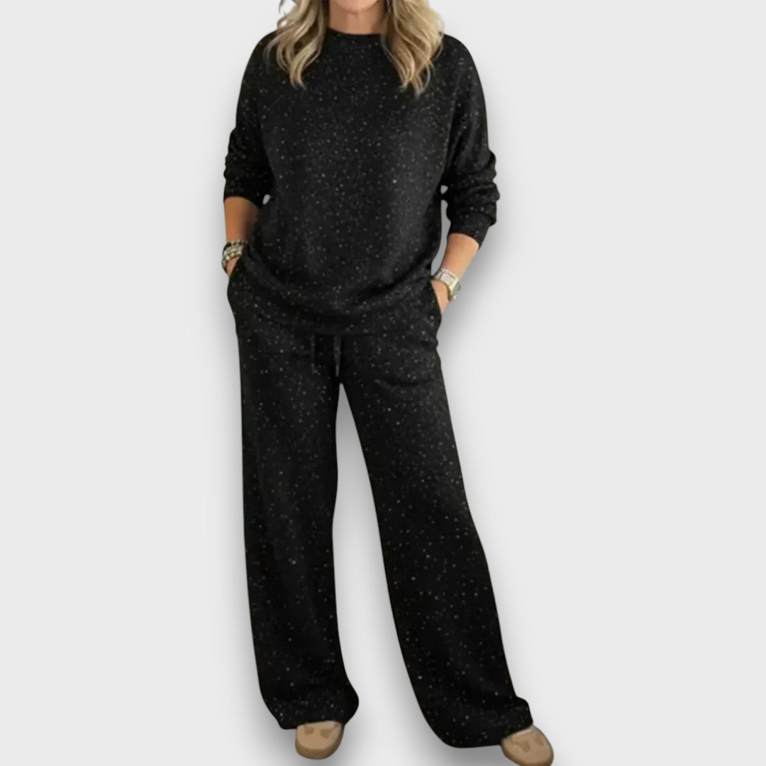 Relaxed two-piece lounge set in soft neutral tones with flowing draped top and wide-leg bottoms