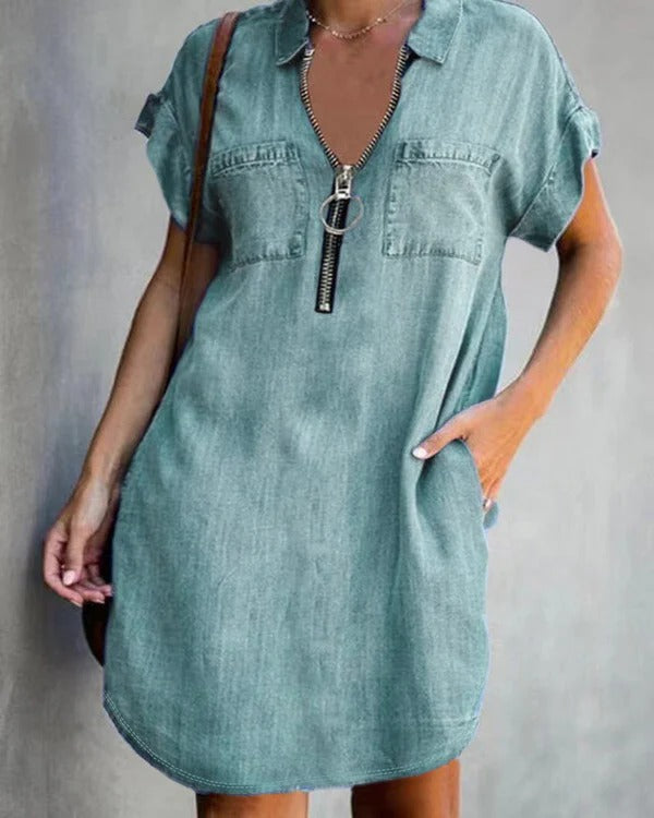 Women's relaxed-fit blue denim dress with short sleeves, front zipper closure, and utility pockets
