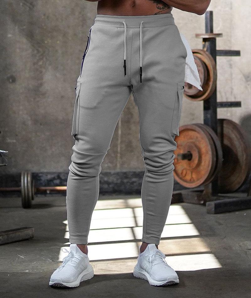 Men's gray athletic joggers with 4-way stretch breathable fabric, multiple pockets, and tapered fit