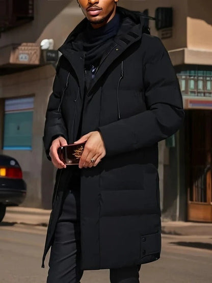 Men's long black puffer coat with hood, zip closure, and extended silhouette for cold-weather layering