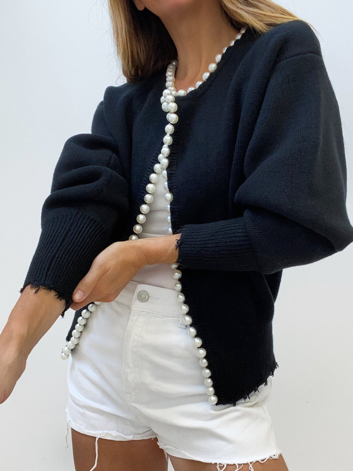 Elegant cream knit cardigan with pearl trim details and stylish ripped hem finish