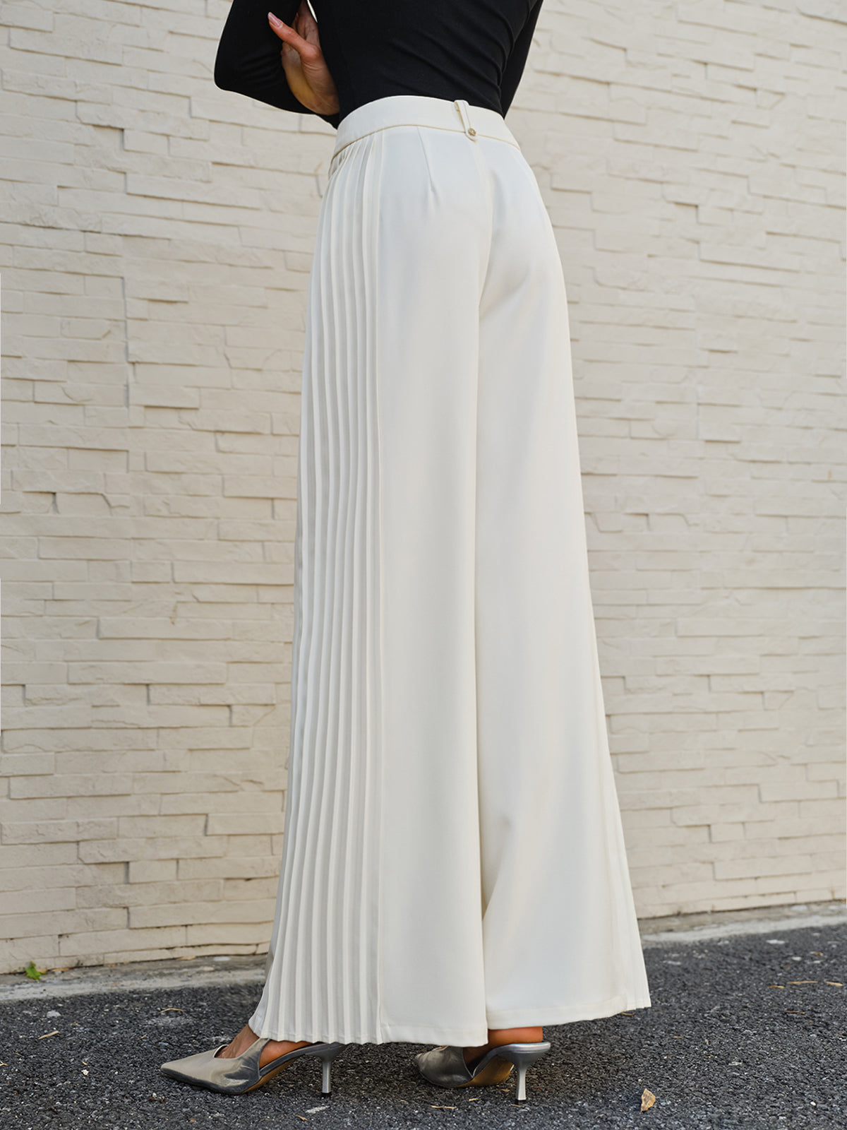 Black wide-leg pleated pants with mid-waist fit and elegant side pleats in woven fabric