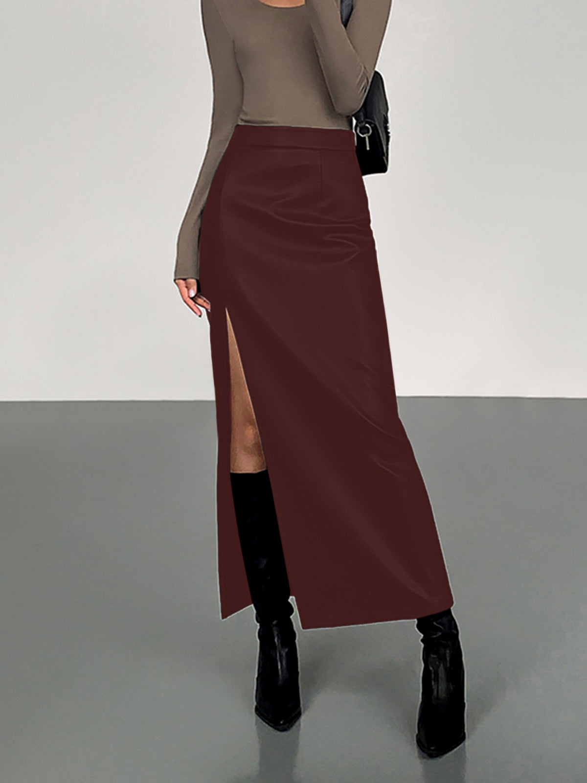 Black high-waist PU faux leather midi skirt with bold side split for modern sleek style