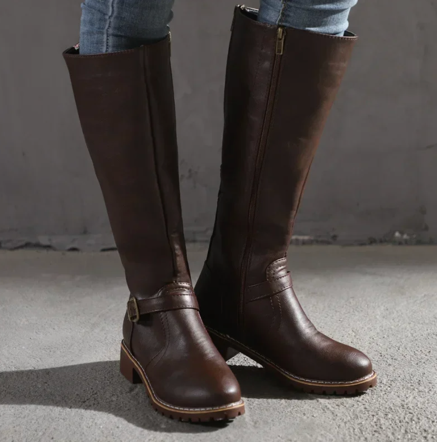 Women's brown knee-high leather boots with sleek silhouette and rich patina finish