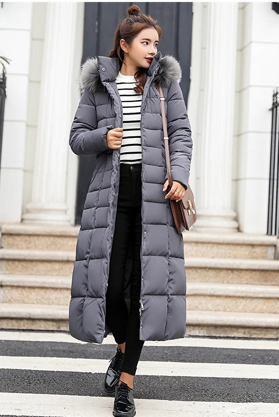 Women's long black quilted puffer coat with belted waist and fur trim hood for winter warmth