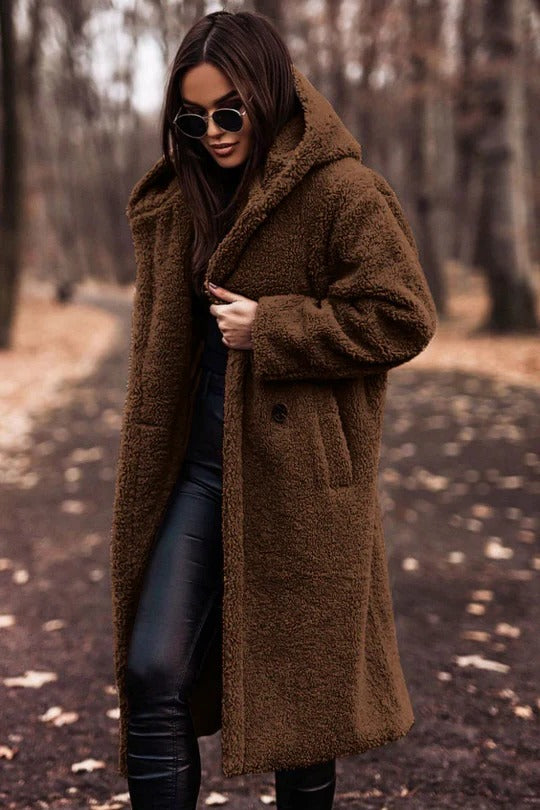 Structured mid-length winter coat with high collar, button closure, waist belt, and insulating thick fabric