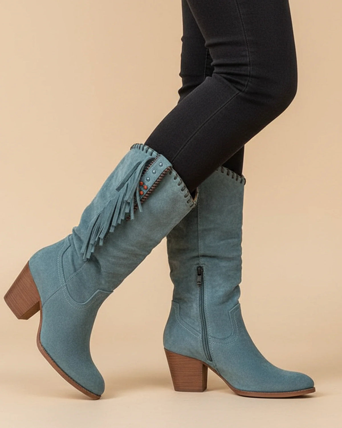 Women's knee-high western boots in tan leather with intricate stitching and stacked heel