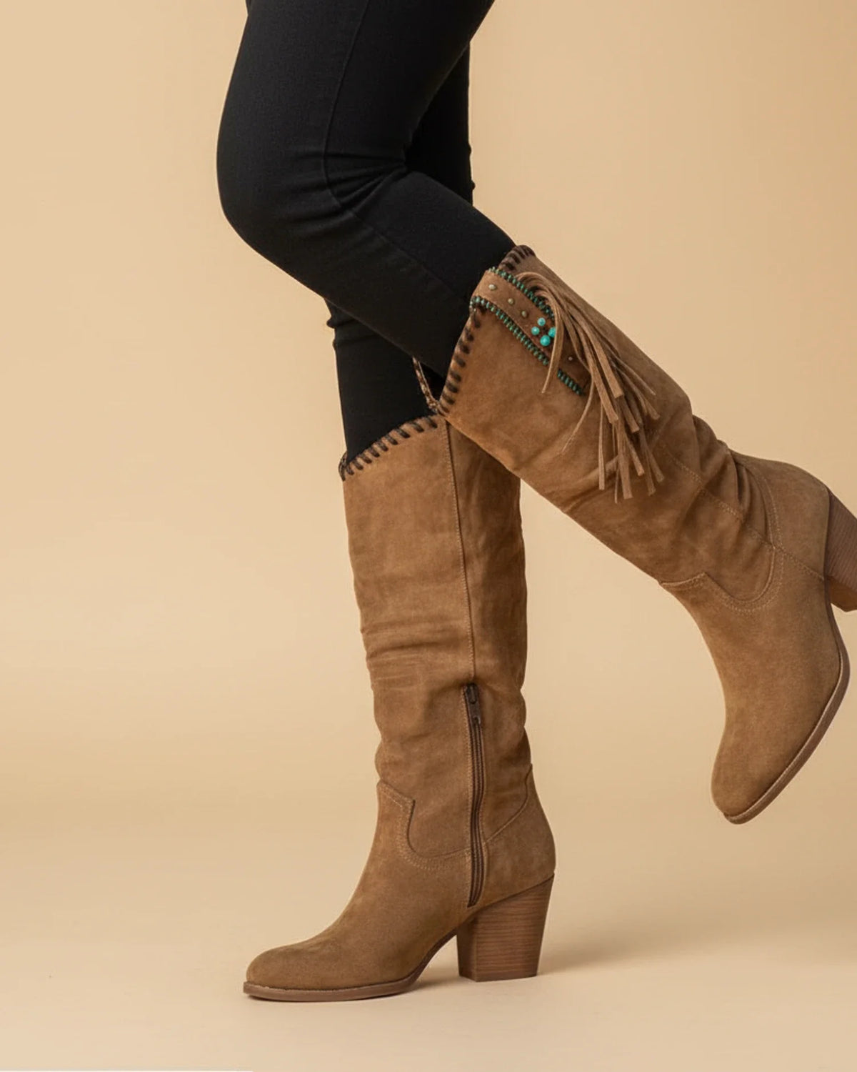 Women's knee-high western boots in tan leather with classic stitching and elongated shaft silhouette