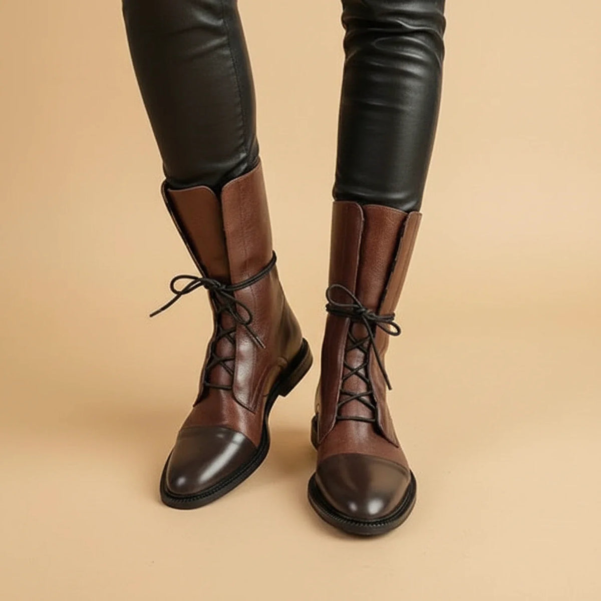 Women's black leather lace-up ankle boots with combat-inspired silhouette and minimalist finish